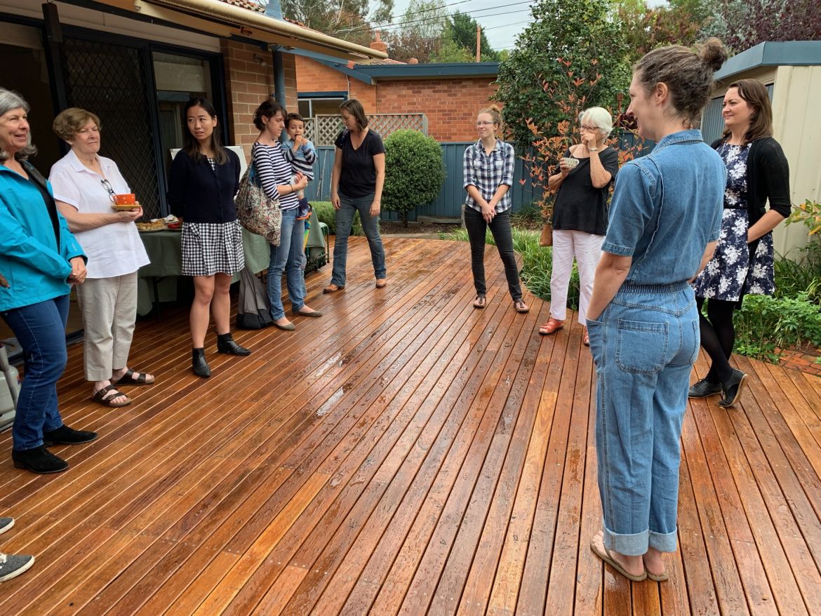 people in a circle having a discussion on a wet deck